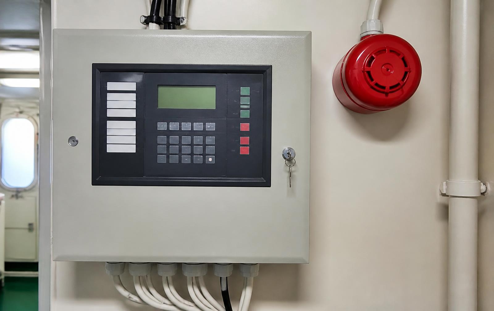 Marine fire alarm control panel and sounder mounted on a vessel bulkhead