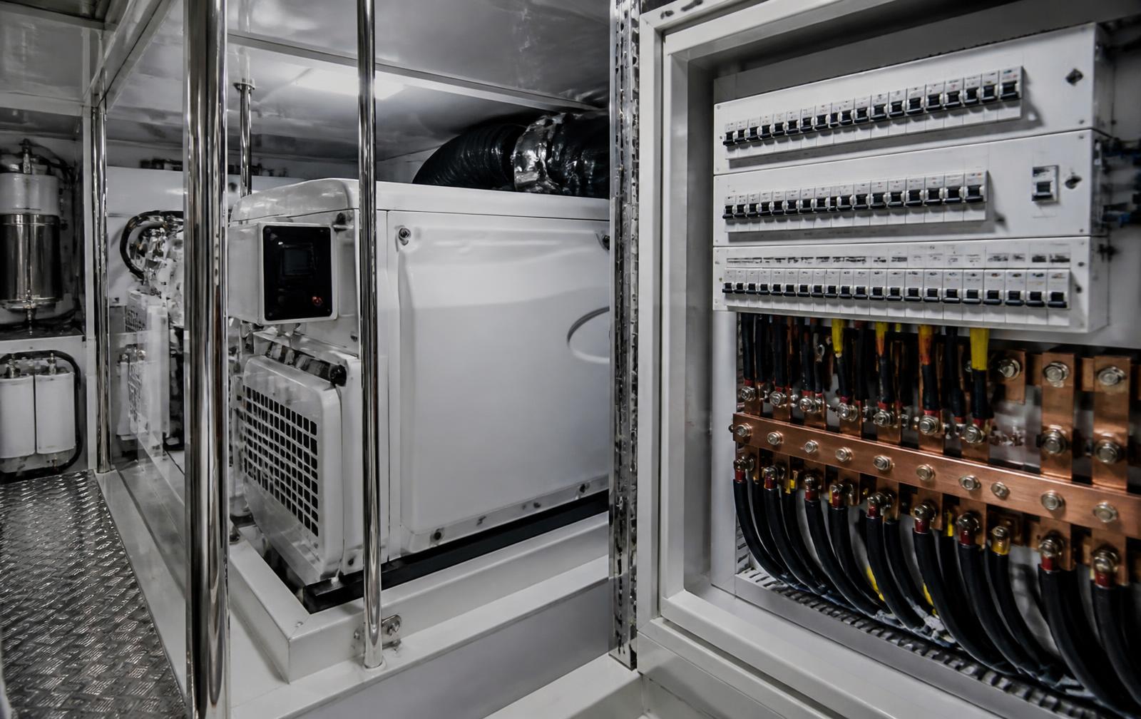 Marine generator and switchgear cabinet with copper bus and labeled breakers in a yacht engine room